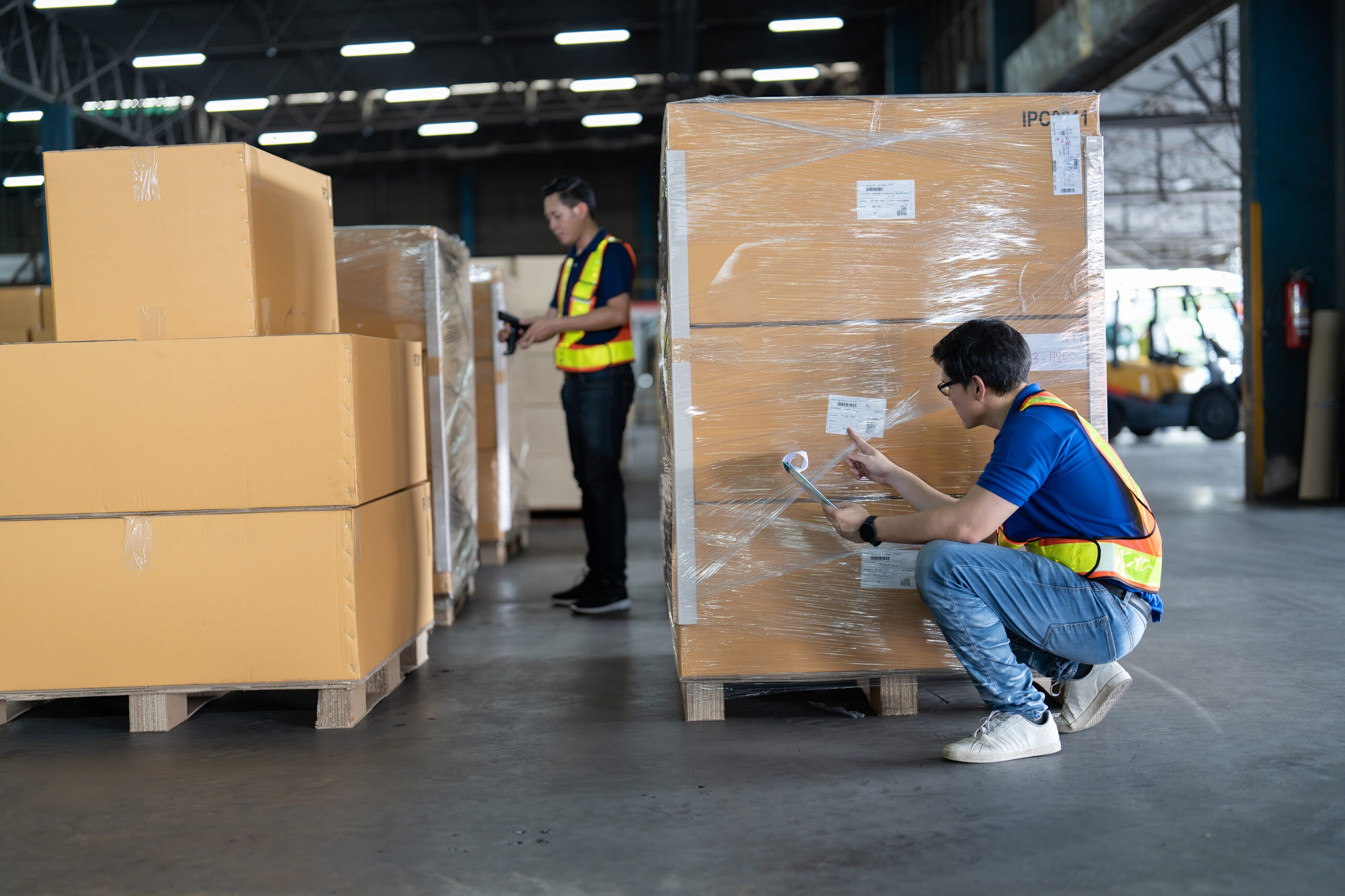 Manager and staff working in warehouse scan barcode looking check list for new arrived boxes
